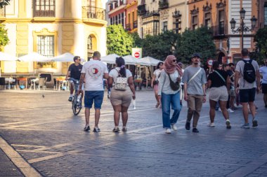 Seville, İspanya, 21 Eylül 2025 Sevilla şehir merkezinin tarihi bölgesini ziyaret eden turistler dar, pitoresk caddelerde yürüyorlar..