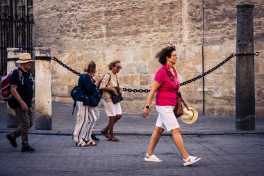 Seville, İspanya, 21 Eylül 2025 Sevilla şehir merkezinin tarihi bölgesini ziyaret eden turistler dar, pitoresk caddelerde yürüyorlar..