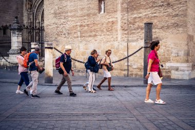 Seville, İspanya, 21 Eylül 2025 Sevilla şehir merkezinin tarihi bölgesini ziyaret eden turistler dar, pitoresk caddelerde yürüyorlar..