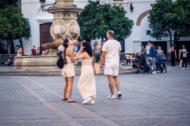 Seville, İspanya, 21 Eylül 2025 Sevilla şehir merkezinin tarihi bölgesini ziyaret eden turistler dar, pitoresk caddelerde yürüyorlar..