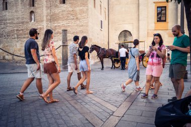 Seville, İspanya, 21 Eylül 2025 Sevilla şehir merkezinin tarihi bölgesini ziyaret eden turistler dar, pitoresk caddelerde yürüyorlar..