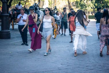 Seville, İspanya, 21 Eylül 2025 Sevilla şehir merkezinin tarihi bölgesini ziyaret eden turistler dar, pitoresk caddelerde yürüyorlar..