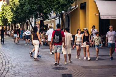Seville, İspanya, 21 Eylül 2025 Sevilla şehir merkezinin tarihi bölgesini ziyaret eden turistler dar, pitoresk caddelerde yürüyorlar..