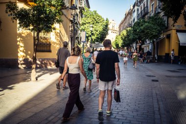 Seville, İspanya, 21 Eylül 2025 Sevilla şehir merkezinin tarihi bölgesini ziyaret eden turistler dar, pitoresk caddelerde yürüyorlar..