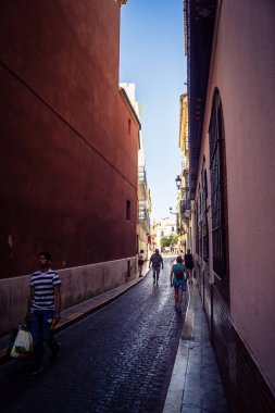 Seville, İspanya, 21 Eylül 2025 Sevilla şehir merkezinin tarihi bölgesini ziyaret eden turistler dar, pitoresk caddelerde yürüyorlar..