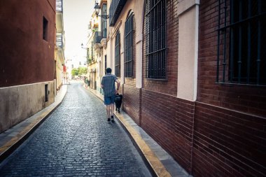 Seville, İspanya, 21 Eylül 2025 Sevilla şehir merkezinin tarihi bölgesini ziyaret eden turistler dar, pitoresk caddelerde yürüyorlar..