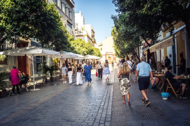 Seville, İspanya, 21 Eylül 2025 Sevilla şehir merkezinin tarihi bölgesini ziyaret eden turistler dar, pitoresk caddelerde yürüyorlar..