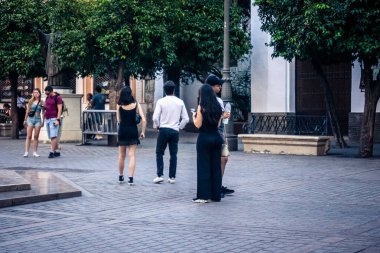 Seville, İspanya, 21 Eylül 2025 Sevilla şehir merkezinin tarihi bölgesini ziyaret eden turistler dar, pitoresk caddelerde yürüyorlar..