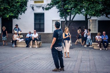 Seville, İspanya, 21 Eylül 2025 Sevilla şehir merkezinin tarihi bölgesini ziyaret eden turistler dar, pitoresk caddelerde yürüyorlar..