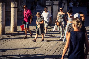 Seville, İspanya, 21 Eylül 2025 Sevilla şehir merkezinin tarihi bölgesini ziyaret eden turistler dar, pitoresk caddelerde yürüyorlar..