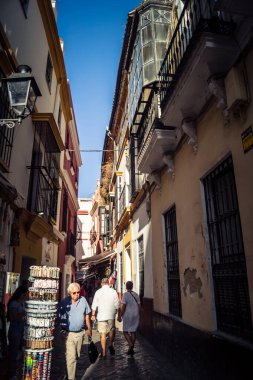 Seville, İspanya, 21 Eylül 2025 Sevilla şehir merkezinin tarihi bölgesini ziyaret eden turistler dar, pitoresk caddelerde yürüyorlar..