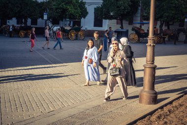 Seville, İspanya, 21 Eylül 2025 Sevilla şehir merkezinin tarihi bölgesini ziyaret eden turistler dar, pitoresk caddelerde yürüyorlar..