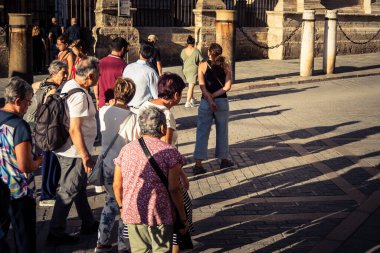 Seville, İspanya, 21 Eylül 2025 Sevilla şehir merkezinin tarihi bölgesini ziyaret eden turistler dar, pitoresk caddelerde yürüyorlar..