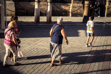Seville, İspanya, 21 Eylül 2025 Sevilla şehir merkezinin tarihi bölgesini ziyaret eden turistler dar, pitoresk caddelerde yürüyorlar..