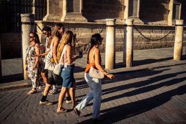 Seville, İspanya, 21 Eylül 2025 Sevilla şehir merkezinin tarihi bölgesini ziyaret eden turistler dar, pitoresk caddelerde yürüyorlar..