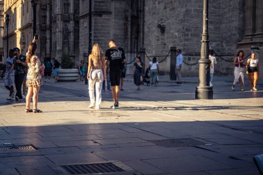 Seville, İspanya, 21 Eylül 2025 Sevilla şehir merkezinin tarihi bölgesini ziyaret eden turistler dar, pitoresk caddelerde yürüyorlar..