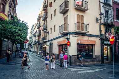 Seville, İspanya, 21 Eylül 2025 Sevilla şehir merkezinin tarihi bölgesini ziyaret eden turistler dar, pitoresk caddelerde yürüyorlar..