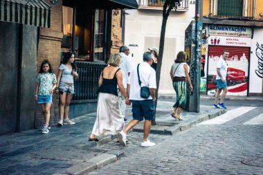 Seville, İspanya, 21 Eylül 2025 Sevilla şehir merkezinin tarihi bölgesini ziyaret eden turistler dar, pitoresk caddelerde yürüyorlar..