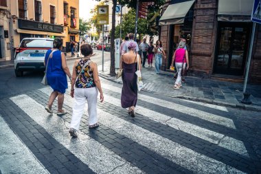Seville, İspanya, 21 Eylül 2025 Sevilla şehir merkezinin tarihi bölgesini ziyaret eden turistler dar, pitoresk caddelerde yürüyorlar..