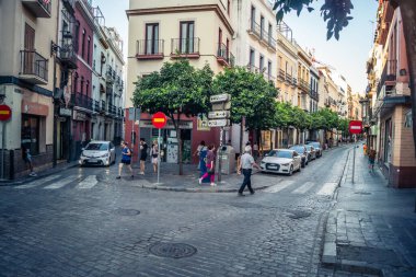 Seville, İspanya, 21 Eylül 2025 Sevilla şehir merkezinin tarihi bölgesini ziyaret eden turistler dar, pitoresk caddelerde yürüyorlar..
