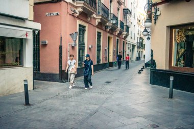 Seville, İspanya, 21 Eylül 2025 Sevilla şehir merkezinin tarihi bölgesini ziyaret eden turistler dar, pitoresk caddelerde yürüyorlar..