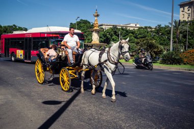 Seville, İspanya, 21 Eylül 2025. Atlı turistler Sevilla şehir merkezinin tarihi bölgesini ziyaret ediyor ve dar, pitoresk caddelerde yürüyor..