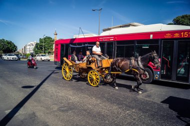 Seville, İspanya, 21 Eylül 2025. Atlı turistler Sevilla şehir merkezinin tarihi bölgesini ziyaret ediyor ve dar, pitoresk caddelerde yürüyor..