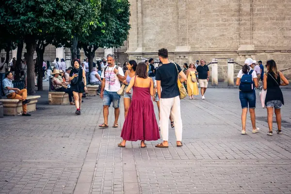 Seville, İspanya, 21 Eylül 2025 Sevilla şehir merkezinin tarihi bölgesini ziyaret eden turistler dar, pitoresk caddelerde yürüyorlar..