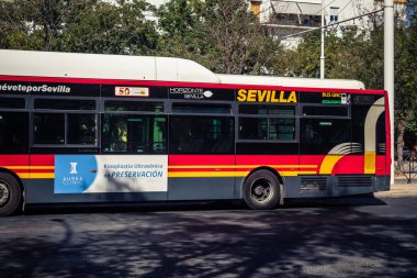 Seville, İspanya, 21 Eylül 2025 Otobüs Sevilla 'nın tarihi şehir merkezinden geçiyor dar, pitoresk caddelerden geçiyor..