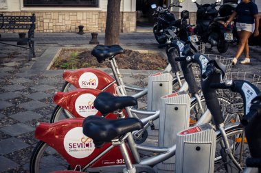 Seville, İspanya, 21 Eylül 2025 Sevilla 'nın tarihi şehir merkezinde, dar, pitoresk caddelerden kiralamak için bisiklet.