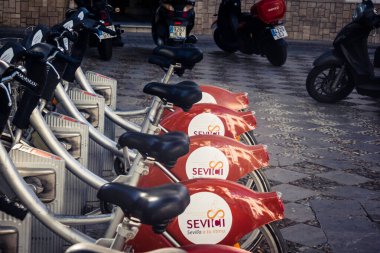 Seville, İspanya, 21 Eylül 2025 Sevilla 'nın tarihi şehir merkezinde, dar, pitoresk caddelerden kiralamak için bisiklet.