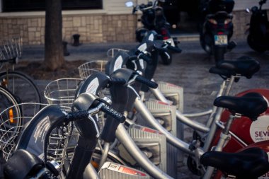 Seville, İspanya, 21 Eylül 2025 Sevilla 'nın tarihi şehir merkezinde, dar, pitoresk caddelerden kiralamak için bisiklet.