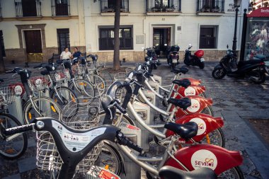Seville, İspanya, 21 Eylül 2025 Sevilla 'nın tarihi şehir merkezinde, dar, pitoresk caddelerden kiralamak için bisiklet.