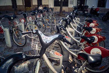 Seville, İspanya, 21 Eylül 2025 Sevilla 'nın tarihi şehir merkezinde, dar, pitoresk caddelerden kiralamak için bisiklet.