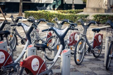 Seville, İspanya, 21 Eylül 2025 Sevilla 'nın tarihi şehir merkezinde, dar, pitoresk caddelerden kiralamak için bisiklet.