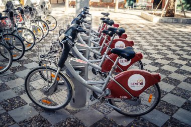 Seville, İspanya, 21 Eylül 2025 Sevilla 'nın tarihi şehir merkezinde, dar, pitoresk caddelerden kiralamak için bisiklet.