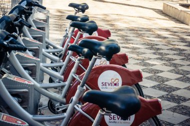 Seville, İspanya, 21 Eylül 2025 Sevilla 'nın tarihi şehir merkezinde, dar, pitoresk caddelerden kiralamak için bisiklet.
