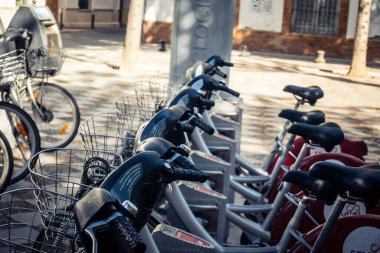 Seville, İspanya, 21 Eylül 2025 Sevilla 'nın tarihi şehir merkezinde, dar, pitoresk caddelerden kiralamak için bisiklet.