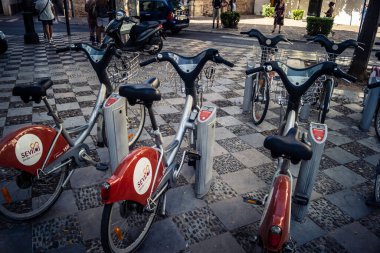 Seville, İspanya, 21 Eylül 2025 Sevilla 'nın tarihi şehir merkezinde, dar, pitoresk caddelerden kiralamak için bisiklet.