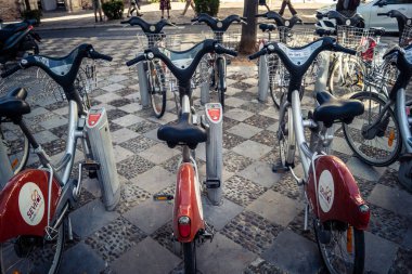 Seville, İspanya, 21 Eylül 2025 Sevilla 'nın tarihi şehir merkezinde, dar, pitoresk caddelerden kiralamak için bisiklet.