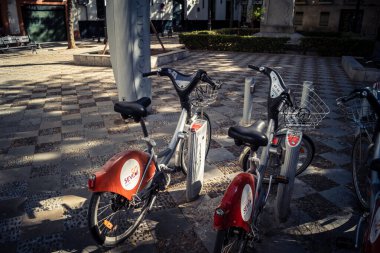 Seville, İspanya, 21 Eylül 2025 Sevilla 'nın tarihi şehir merkezinde, dar, pitoresk caddelerden kiralamak için bisiklet.