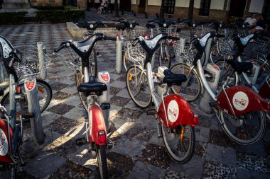 Seville, İspanya, 21 Eylül 2025 Sevilla 'nın tarihi şehir merkezinde, dar, pitoresk caddelerden kiralamak için bisiklet.