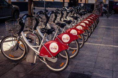Seville, İspanya, 21 Eylül 2025 Sevilla 'nın tarihi şehir merkezinde, dar, pitoresk caddelerden kiralamak için bisiklet.