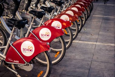 Seville, İspanya, 21 Eylül 2025 Sevilla 'nın tarihi şehir merkezinde, dar, pitoresk caddelerden kiralamak için bisiklet.