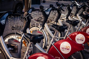 Seville, İspanya, 21 Eylül 2025 Sevilla 'nın tarihi şehir merkezinde, dar, pitoresk caddelerden kiralamak için bisiklet.