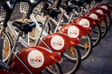 Seville, İspanya, 21 Eylül 2025 Sevilla 'nın tarihi şehir merkezinde, dar, pitoresk caddelerden kiralamak için bisiklet.