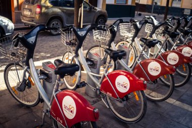 Seville, İspanya, 21 Eylül 2025 Sevilla 'nın tarihi şehir merkezinde, dar, pitoresk caddelerden kiralamak için bisiklet.