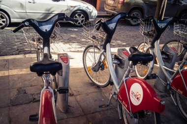 Seville, İspanya, 21 Eylül 2025 Sevilla 'nın tarihi şehir merkezinde, dar, pitoresk caddelerden kiralamak için bisiklet.