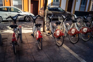 Seville, İspanya, 21 Eylül 2025 Sevilla 'nın tarihi şehir merkezinde, dar, pitoresk caddelerden kiralamak için bisiklet.