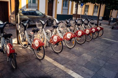 Seville, İspanya, 21 Eylül 2025 Sevilla 'nın tarihi şehir merkezinde, dar, pitoresk caddelerden kiralamak için bisiklet.